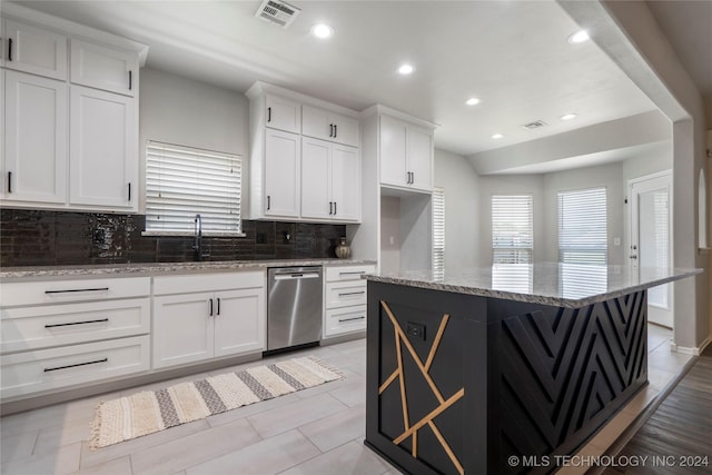 kitchen with light stone countertops, a kitchen island, sink, dishwasher, and white cabinetry