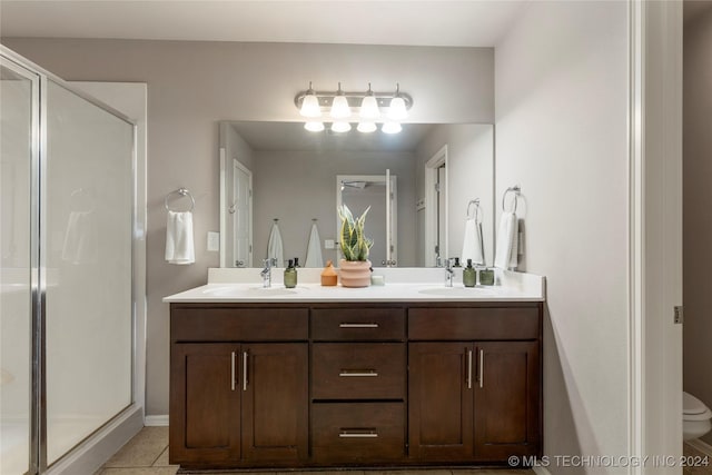 bathroom with tile patterned flooring, vanity, an enclosed shower, and toilet