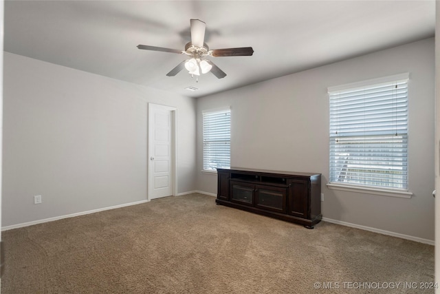 spare room featuring light colored carpet and ceiling fan