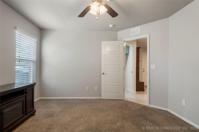 carpeted spare room featuring ceiling fan