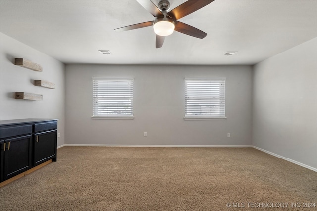 carpeted empty room featuring plenty of natural light and ceiling fan