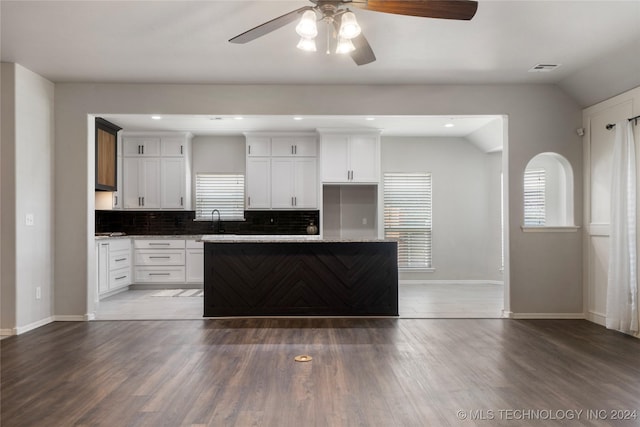 kitchen featuring white cabinetry, dark wood-type flooring, and lofted ceiling