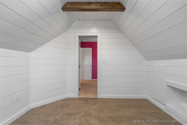 bonus room with carpet flooring, lofted ceiling with beams, and wood walls