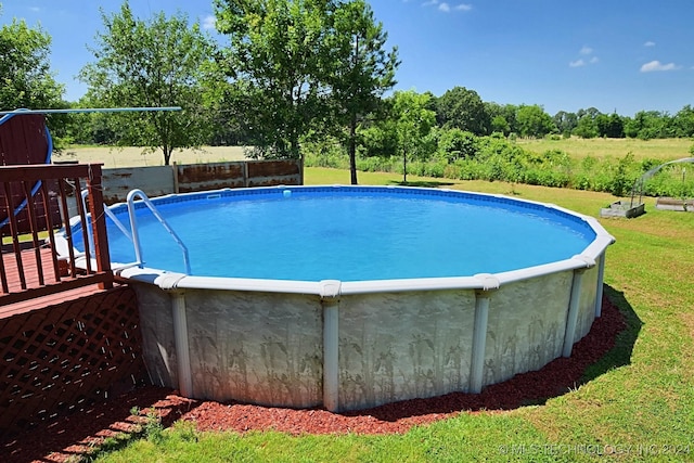 view of pool featuring a lawn