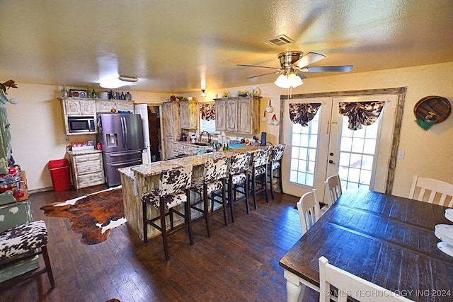 kitchen featuring dark hardwood / wood-style floors, a kitchen breakfast bar, kitchen peninsula, and appliances with stainless steel finishes