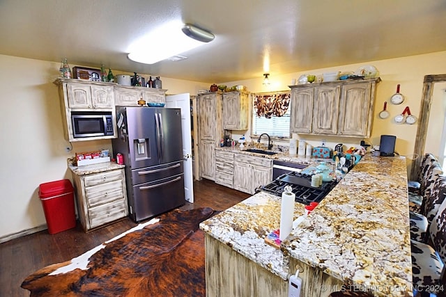 kitchen with dark wood-type flooring, sink, stainless steel fridge, built in microwave, and light stone counters