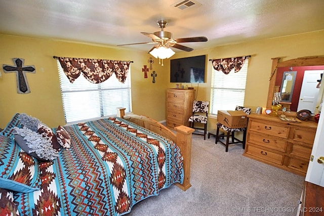 carpeted bedroom with ceiling fan and a textured ceiling