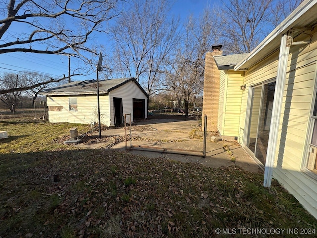 view of side of home featuring a garage and an outdoor structure