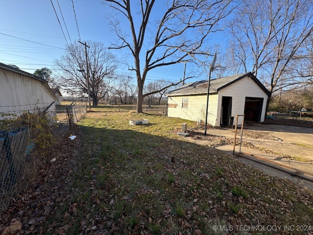 view of yard featuring a garage and an outbuilding