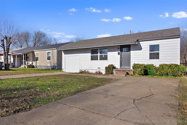 ranch-style house featuring a garage and a front lawn