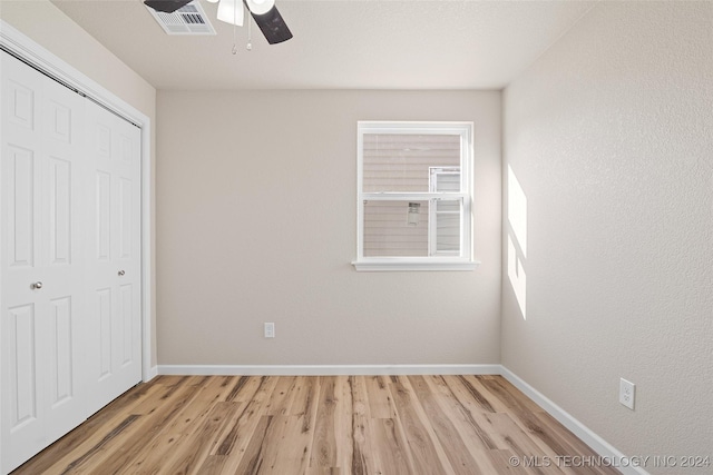 unfurnished bedroom with ceiling fan, a closet, and light wood-type flooring