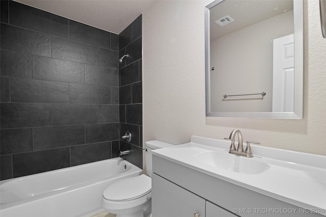 full bathroom featuring vanity, tiled shower / bath combo, and toilet