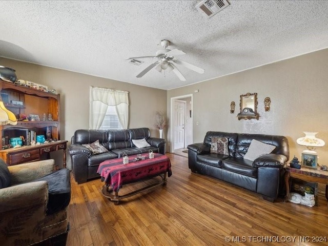 living room with ceiling fan, a textured ceiling, and hardwood / wood-style flooring