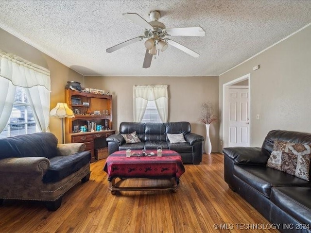 living room with a textured ceiling, hardwood / wood-style flooring, plenty of natural light, and ceiling fan