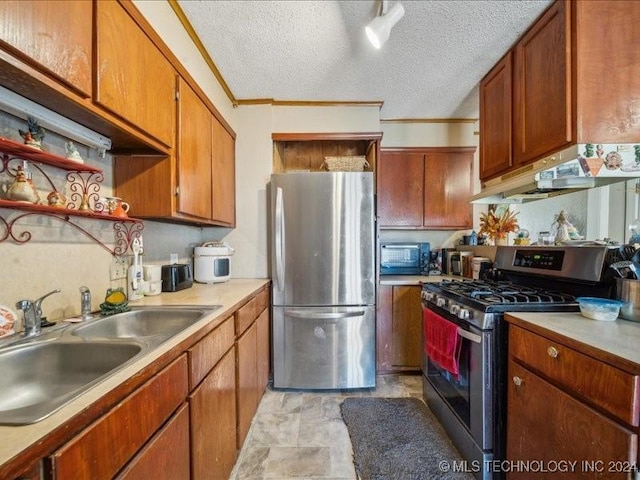 kitchen featuring appliances with stainless steel finishes, a textured ceiling, crown molding, and sink