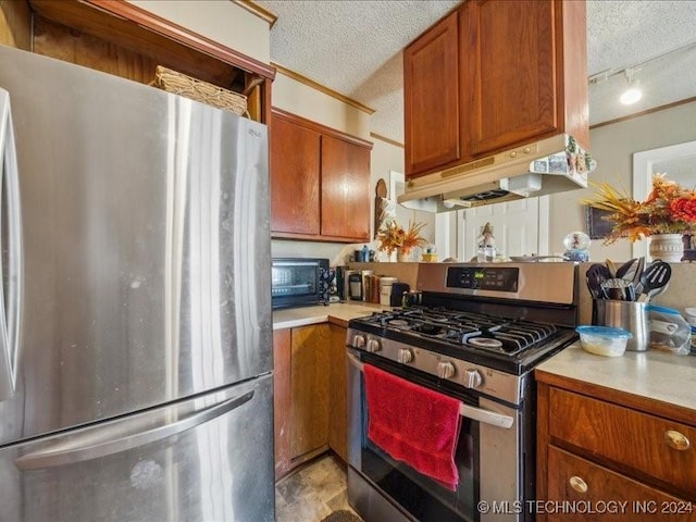 kitchen featuring a textured ceiling, stainless steel appliances, and track lighting