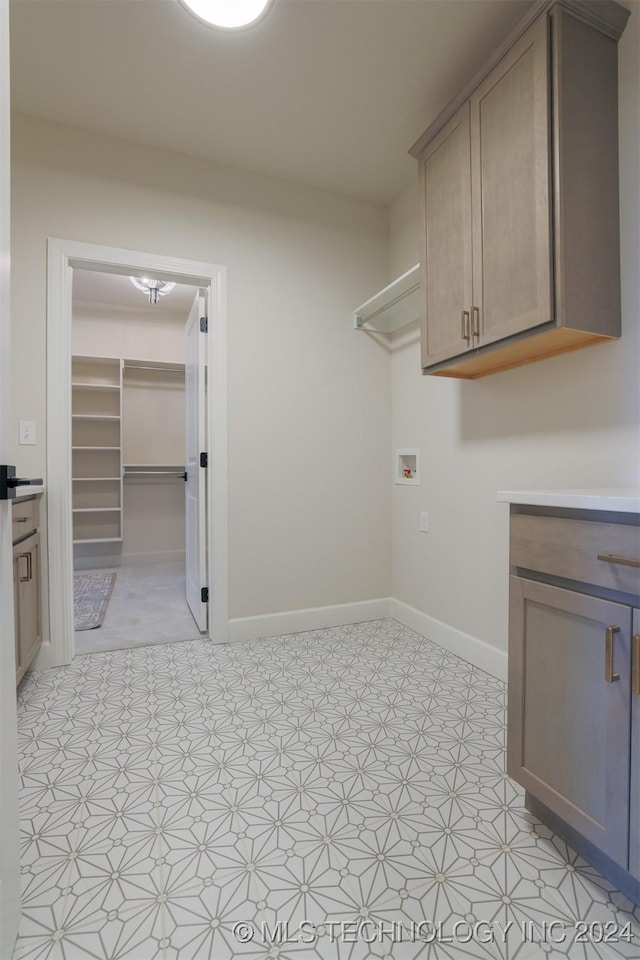 laundry area with washer hookup, laundry area, light floors, and baseboards