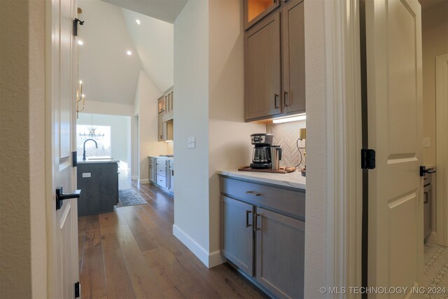 kitchen with hardwood / wood-style floors and vaulted ceiling