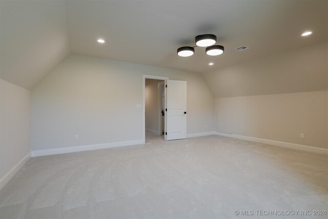 bonus room featuring light carpet and vaulted ceiling