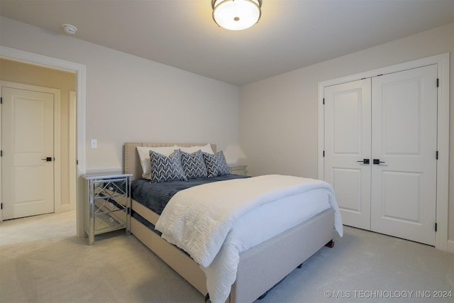 bedroom with light carpet and a closet