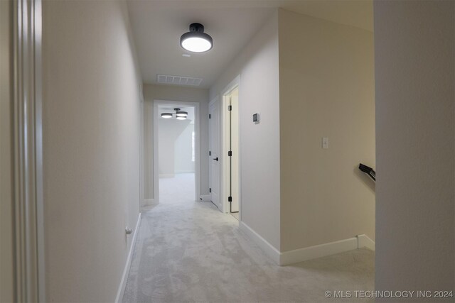 corridor featuring light colored carpet