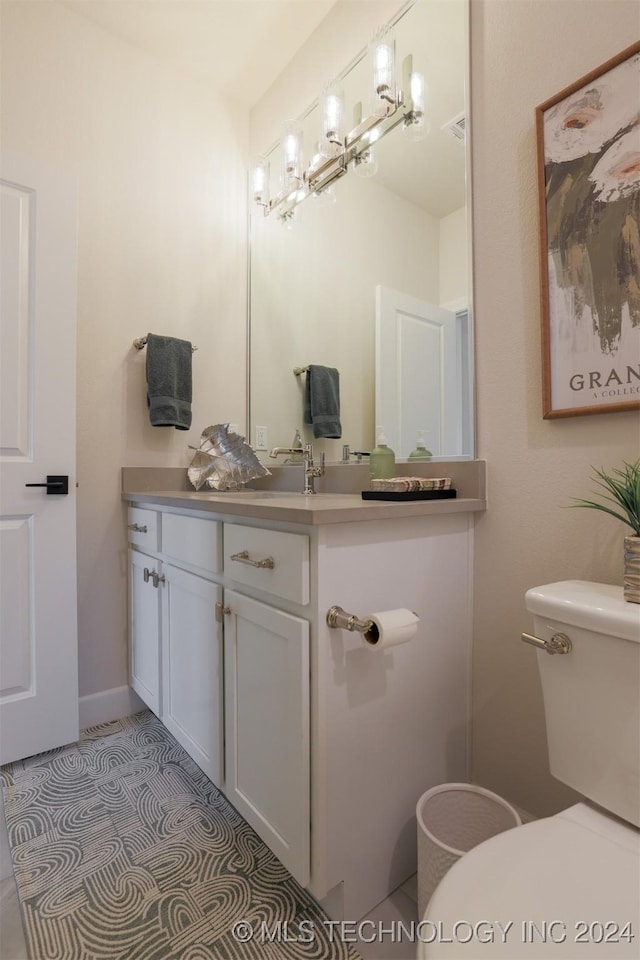 bathroom featuring tile patterned flooring, vanity, and toilet