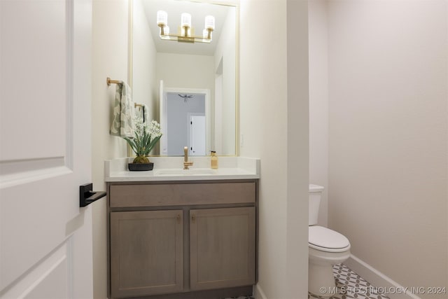 half bathroom with toilet, vanity, and baseboards