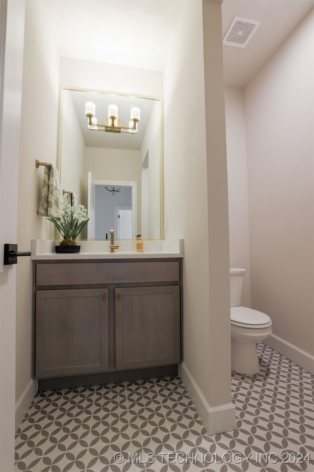 half bath with visible vents, baseboards, toilet, and vanity