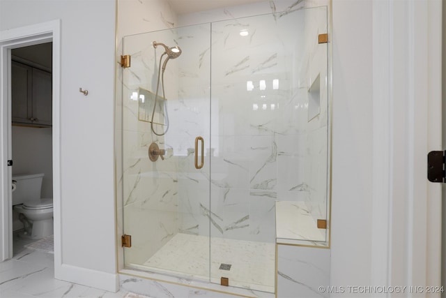 bathroom featuring a marble finish shower, baseboards, toilet, and marble finish floor