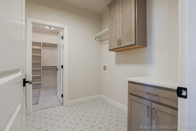 laundry room with cabinets, light tile patterned floors, and washer hookup