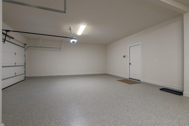 garage featuring a garage door opener and baseboards