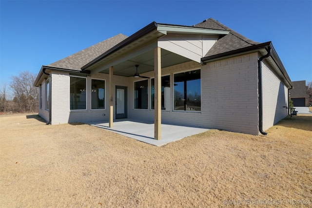 rear view of house featuring a patio area, brick siding, and a shingled roof