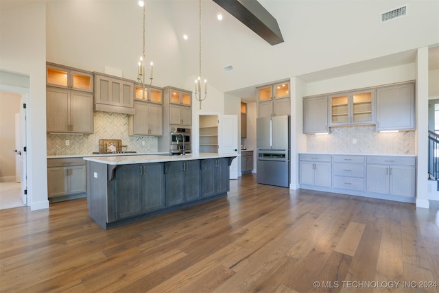 kitchen with a spacious island, visible vents, dark wood finished floors, light countertops, and stainless steel appliances