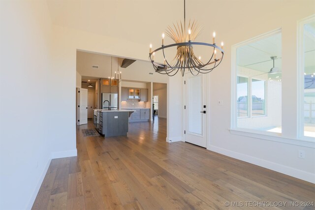 unfurnished dining area with hardwood / wood-style flooring and a notable chandelier