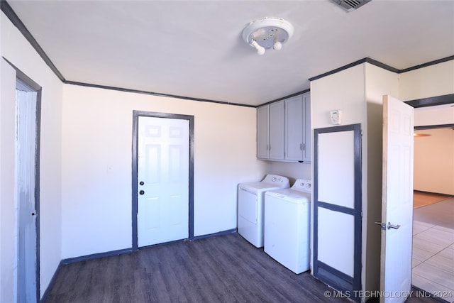 laundry room with cabinets, crown molding, washer and dryer, and dark hardwood / wood-style floors