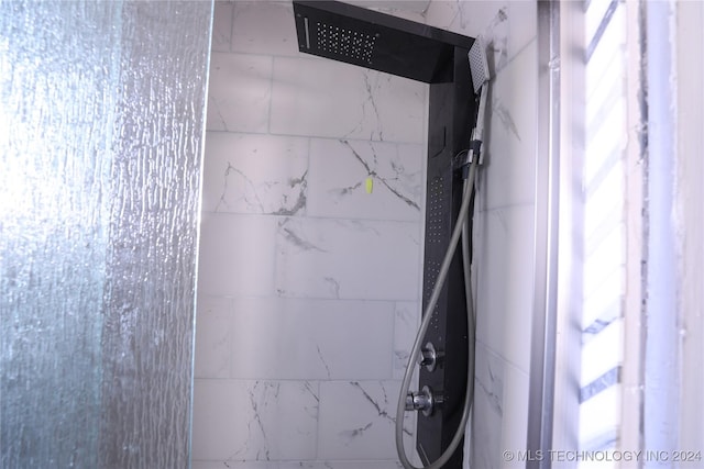 interior details with a tile shower