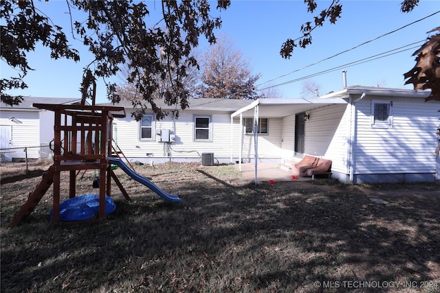 view of jungle gym featuring central AC unit and a lawn