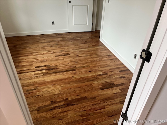 unfurnished room with dark wood-type flooring