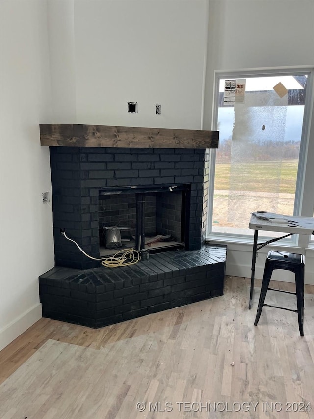 details with wood-type flooring and a brick fireplace