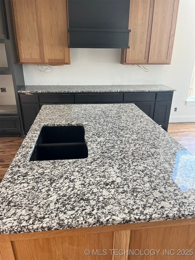 kitchen featuring hardwood / wood-style flooring and light stone countertops