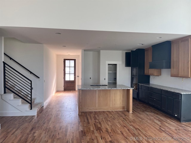 kitchen featuring light stone countertops, wood-type flooring, and a kitchen island