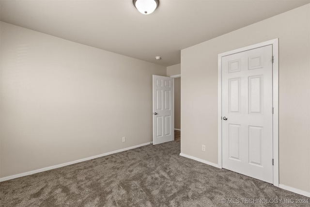 unfurnished bedroom featuring dark carpet