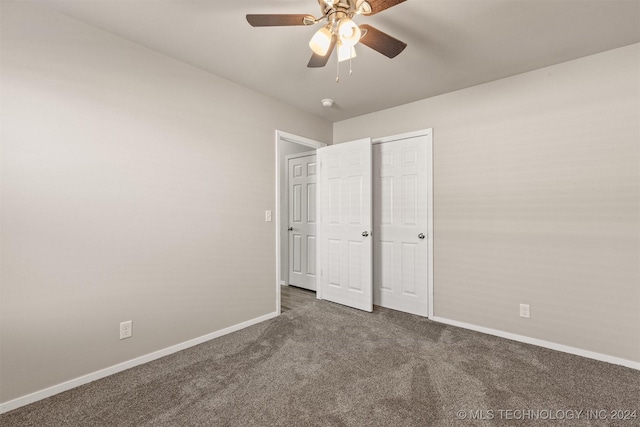 unfurnished bedroom with ceiling fan, a closet, and dark carpet