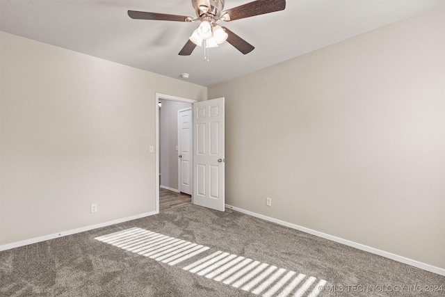 carpeted spare room featuring ceiling fan