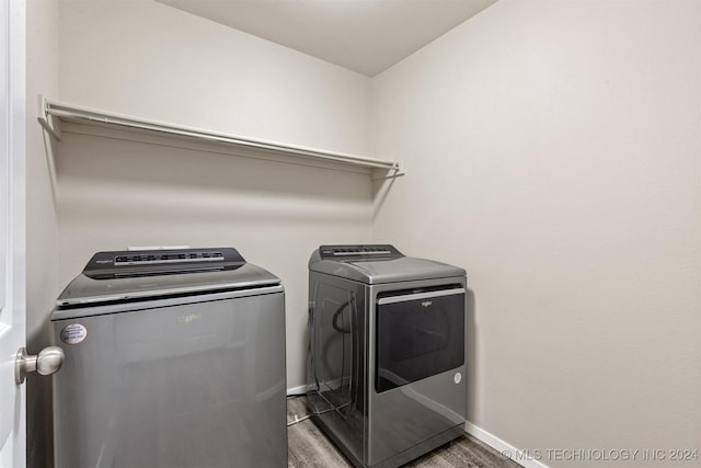 laundry room with hardwood / wood-style flooring and washer and dryer