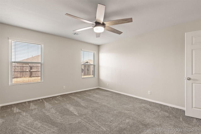 carpeted spare room with plenty of natural light and ceiling fan