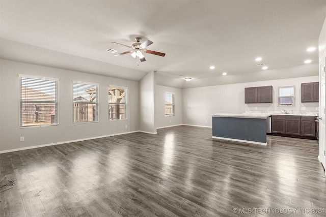 unfurnished living room with ceiling fan, sink, and dark wood-type flooring