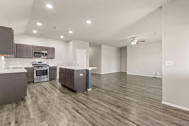 kitchen with ceiling fan, a kitchen island, stainless steel appliances, and wood-type flooring