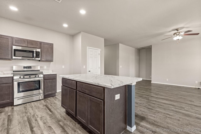 kitchen with a center island, dark brown cabinetry, dark wood-type flooring, and appliances with stainless steel finishes