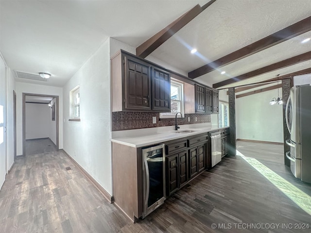 kitchen with dark brown cabinetry, sink, stainless steel appliances, hardwood / wood-style floors, and decorative backsplash